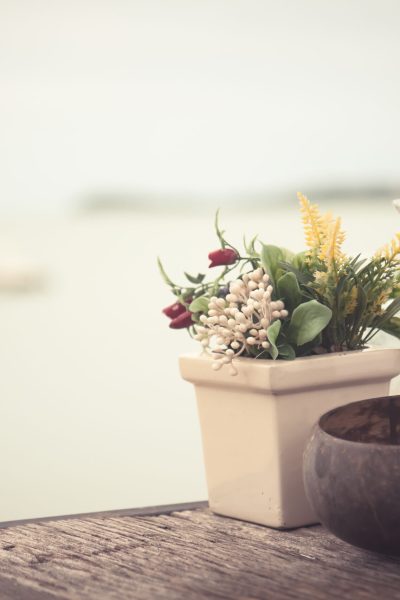 Beach view from cafe in vintage style with decoration accessories in rustic Provence style on old wooden table and horizon over sea